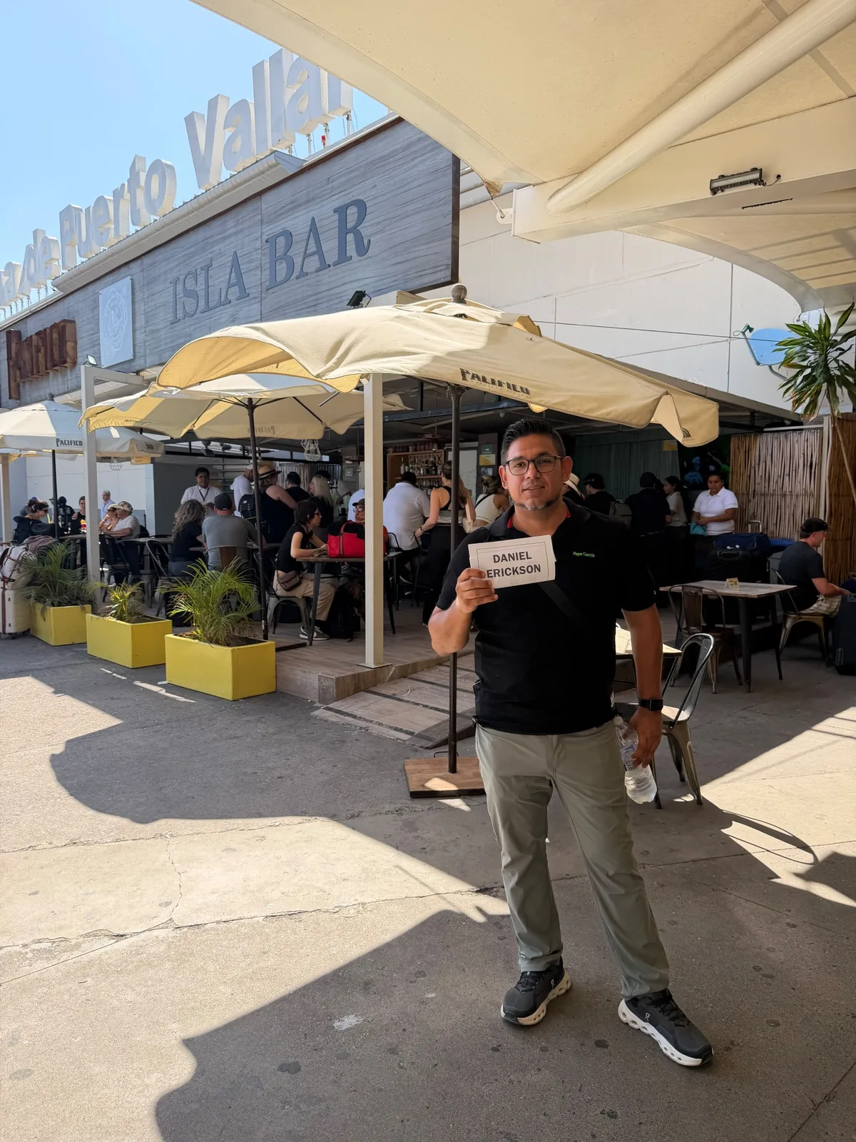 Vallarta Roots host holding a personalized welcome sign for an arriving guest
