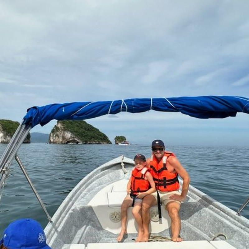 Boat beside the towering arches of Los Arcos
