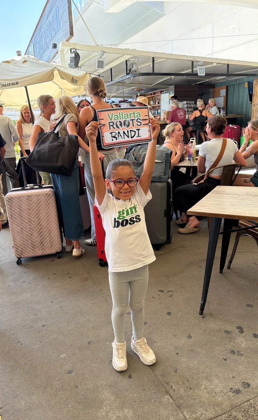 Pepe’s daughter proudly holding a Vallarta Roots welcome sign for arriving guests