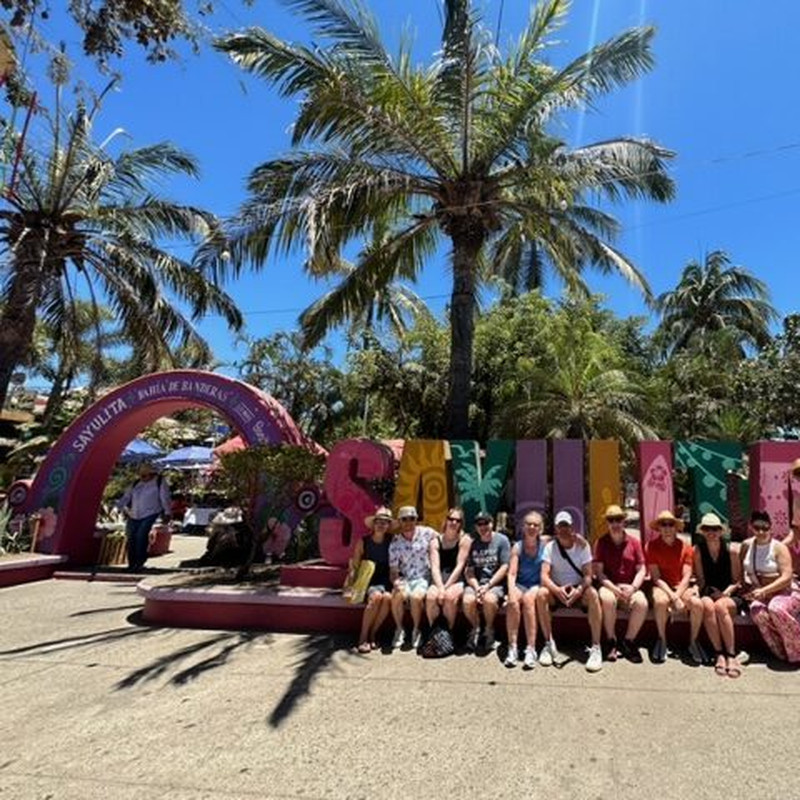 Guests seated at the Sayulita town sign