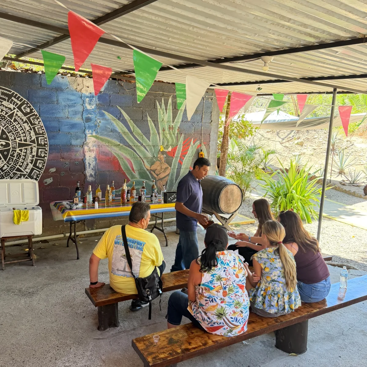 Vallarta Roots guests learning about and tasting tequila beneath a palapa